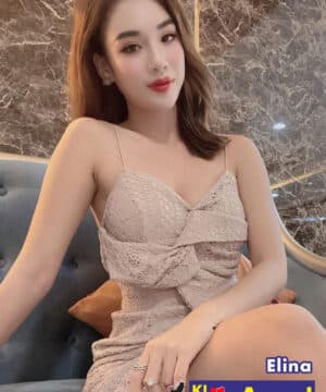 Portrait of a woman in a beige lace dress sitting on a sofa, with 'Elina' and 'KL escort Angel' branding in the corner.